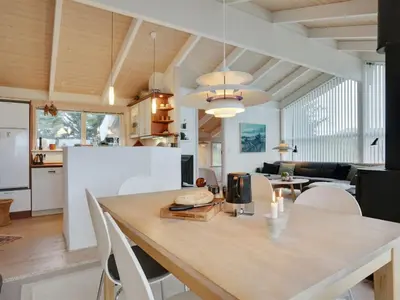 a kitchen and dining room with a table and chairs at Holiday Home Lennja - 300m from the sea by Interhome in Saltum