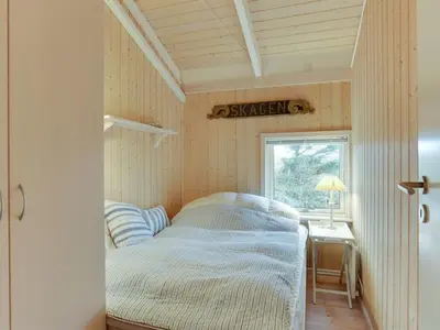 a bed in a small room with a window at Holiday Home Lennja - 300m from the sea by Interhome in Saltum