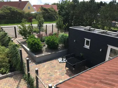 an aerial view of a backyard with a black house at Casa Uno North - Nice appartement for two with sea view in Farsø