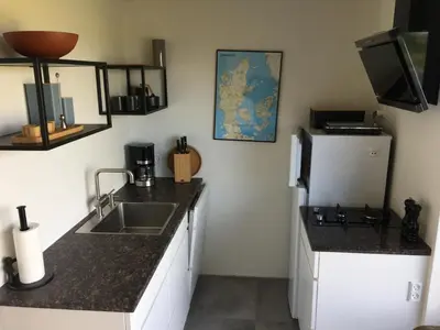 a kitchen with a sink and a refrigerator at Casa Uno North - Nice appartement for two with sea view in Farsø
