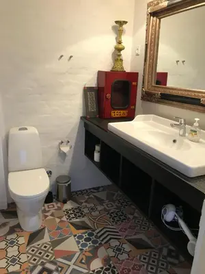 a bathroom with a sink and a toilet and a mirror at Holstebro Sky Studio in Holstebro
