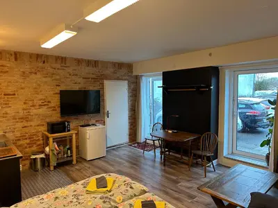 a living room with a television and a dining room table at Holstebro Sky Studio in Holstebro