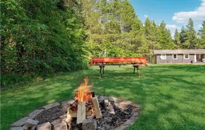 a fire pit in a yard with a red piano at Nice Home In Højslev With Kitchen in Højslev