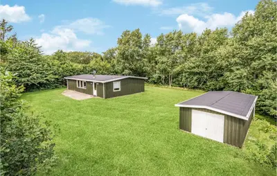 two small buildings in a grassy yard with trees at Holiday Home Illeris Farsø Vi in Farsø