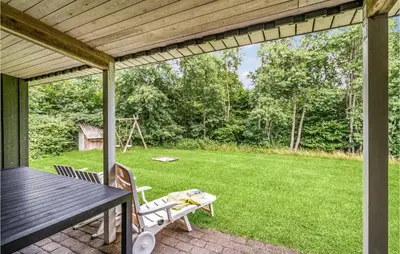 a patio with a table and chairs and a yard at Holiday Home Illeris Farsø Vi in Farsø