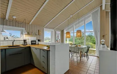 a kitchen and dining room with a table and chairs at Holiday Home Bavnbak Thisted Iv in Thisted