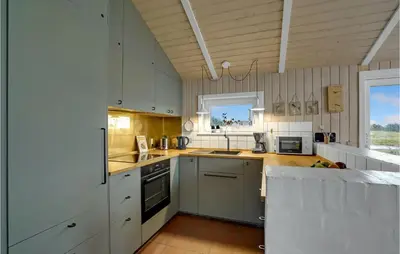 a kitchen with white cabinets and a stove top oven at Holiday Home Bavnbak Thisted Iv in Thisted