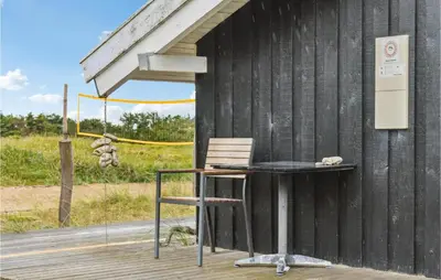 a chair and a table outside of a building at Holiday Home Bavnbak Thisted Iv in Thisted