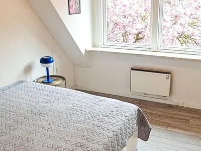 a bedroom with a bed and two windows at 8 person holiday home in Øster Assels-By Traum in Øster Assels
