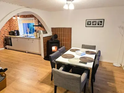 a dining room with a table and chairs and a kitchen at 8 person holiday home in Øster Assels-By Traum in Øster Assels