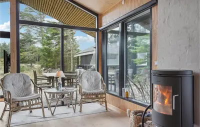 a living room with a fireplace and a table and chairs at Awesome Home In Saltum With Wifi in Saltum