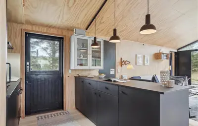 a kitchen with black cabinets and a black door at Awesome Home In Saltum With Wifi in Saltum