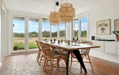 a dining room with a table and chairs and windows at Nice Home In Fjerritslev With Wifi in Fjerritslev
