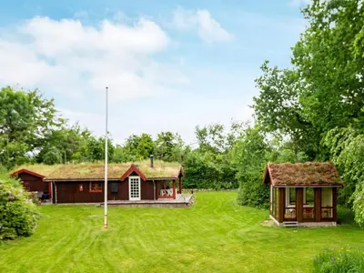 a house with a grassy yard next to a building at 6 person holiday home in Roslev-By Traum in Roslev