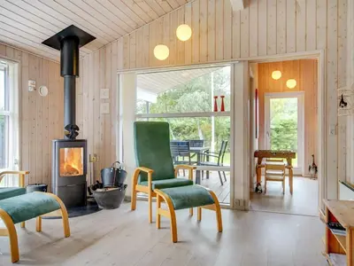 a living room with a wood stove and chairs at Holiday Home Ønder - 800m from the sea by Interhome in Blokhus