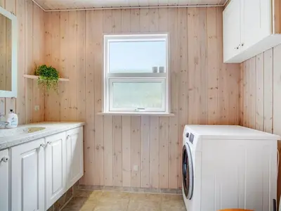 a laundry room with a washing machine and a window at Holiday Home Ønder - 800m from the sea by Interhome in Blokhus