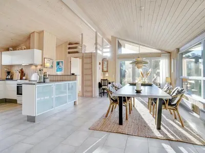 a kitchen and dining room with a table and chairs at Holiday Home Gun - 450m from the sea by Interhome in Blokhus