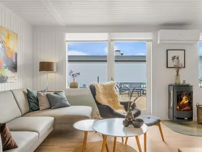 a living room with a couch and a fireplace at Holiday Home Tarvo - 400m from the sea by Interhome in Pandrup