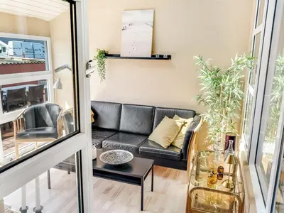 a living room with a black leather couch at Holiday Home Jenvold - 600m from the sea by Interhome in Torsted