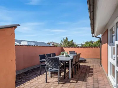 a patio with a table and chairs on a brick patio at Holiday Home Jenvold - 600m from the sea by Interhome in Torsted