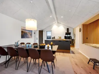 a kitchen and dining room with a table and chairs at Holiday Home Ivar - 300m from the sea by Interhome in Harboør