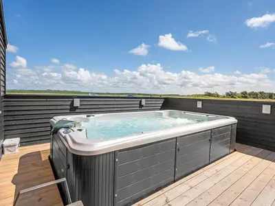 a hot tub on the deck of a house at Holiday Home Ivar - 300m from the sea by Interhome in Harboør