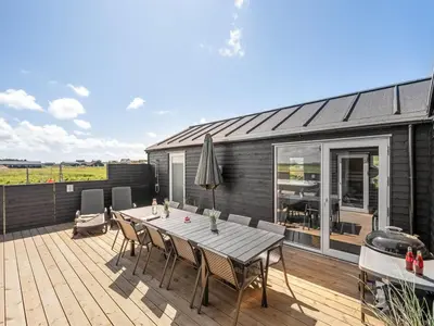 a deck with a table and chairs on a house at Holiday Home Ivar - 300m from the sea by Interhome in Harboør