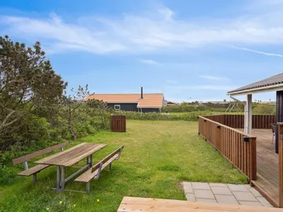 a picnic table and bench in a yard at Holiday Home Wolter - 700m from the sea by Interhome in Harboør
