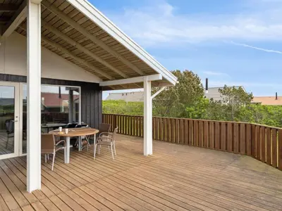 a patio with a table and chairs on a deck at Holiday Home Wolter - 700m from the sea by Interhome in Harboør