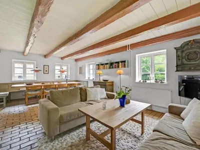 a living room with two couches and a table at Holiday Home Tatiane - 10km from the sea by Interhome in Bækmarksbro
