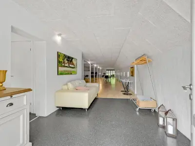 a living room with a white couch and a hallway at Holiday Home Tatiane - 10km from the sea by Interhome in Bækmarksbro