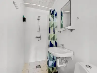 a white bathroom with a sink and a mirror at Holiday Home Tatiane - 10km from the sea by Interhome in Bækmarksbro