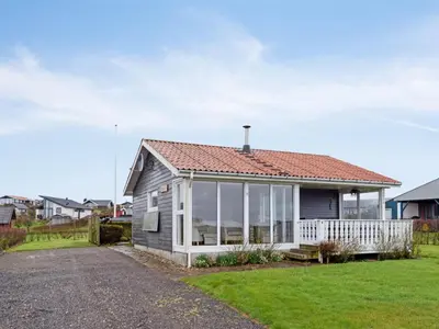 a small house with a porch and windows at Holiday Home Ormar - 100m to the fjord by Interhome in Lemvig