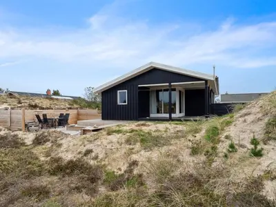 a black house on top of a hill at Holiday Home Sulo - 1-4km from the sea by Interhome in Torsted