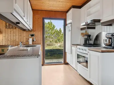 a kitchen with white appliances and a large window at Holiday Home Sulo - 1-4km from the sea by Interhome in Torsted