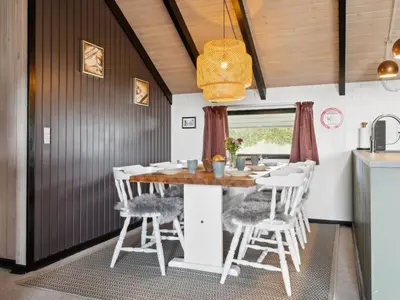 a dining room with a table and white chairs at Holiday Home Myrte - 900m from the sea by Interhome in Torsted