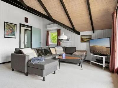 a living room with a couch and a tv at Holiday Home Myrte - 900m from the sea by Interhome in Torsted