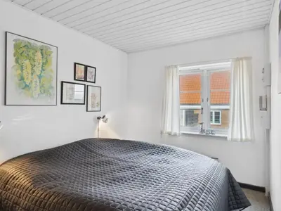 a bedroom with a bed and a window at Holiday Home Ubbe - 200m from the sea by Interhome in Lemvig