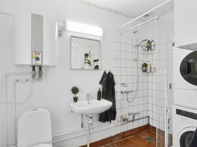 a white bathroom with a sink and a washing machine at Holiday Home Ubbe - 200m from the sea by Interhome in Lemvig