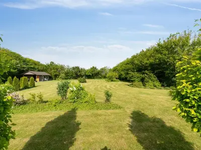 a large grassy field with a house in the background at Apartment Dietlinde - 1-3km to the fjord by Interhome in Thyholm