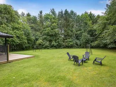a group of chairs sitting in a yard with a playground at Holiday Home Gudrid - 250m to the fjord by Interhome in Højslev