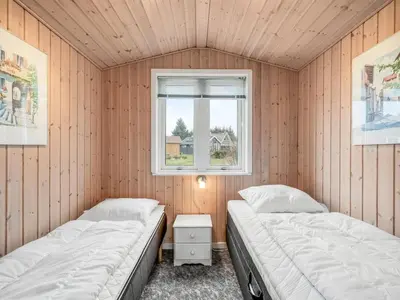 two beds in a room with a window at Holiday Home Bosi - 100m to the fjord by Interhome in Højslev