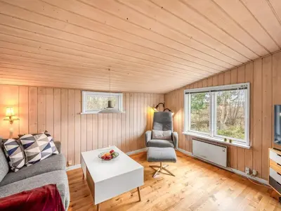 a living room with a couch and a table at Holiday Home Bosi - 100m to the fjord by Interhome in Højslev