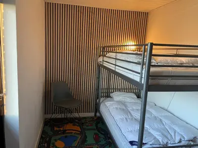 a room with two bunk beds and a chair at Holiday Home Ingward - 750m from the sea by Interhome in Vestervig