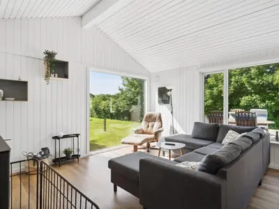 a living room with a couch and a chair at Holiday Home Bjerne - 250m to the fjord by Interhome in Roslev