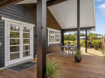 a patio with a table and chairs on a wooden deck at Holiday Home Gizella - 500m to the fjord by Interhome in Spottrup