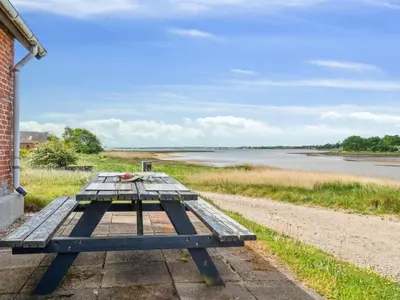 a picnic table sitting next to a body of water at Holiday Home Swaantje - 150m to the fjord by Interhome in Fur