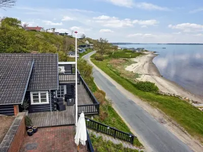 a view of the beach from the balcony of a house at Holiday Home Sander - 10m to the fjord by Interhome in Roslev
