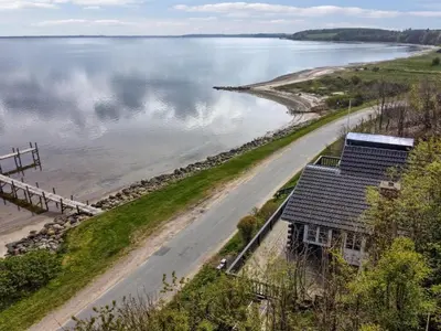 an aerial view of a house next to a body of water at Holiday Home Sander - 10m to the fjord by Interhome in Roslev