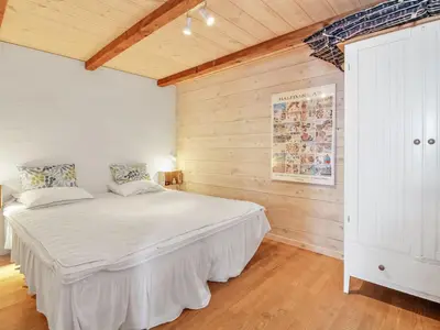 a bedroom with a large white bed in a room at Holiday Home Sander - 10m to the fjord by Interhome in Roslev